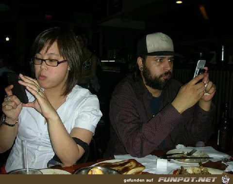 junge Leute nach dem Essen mit Handys