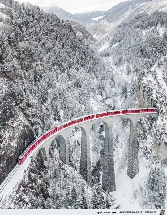 Ein Zug zwischen Bergen im Winter