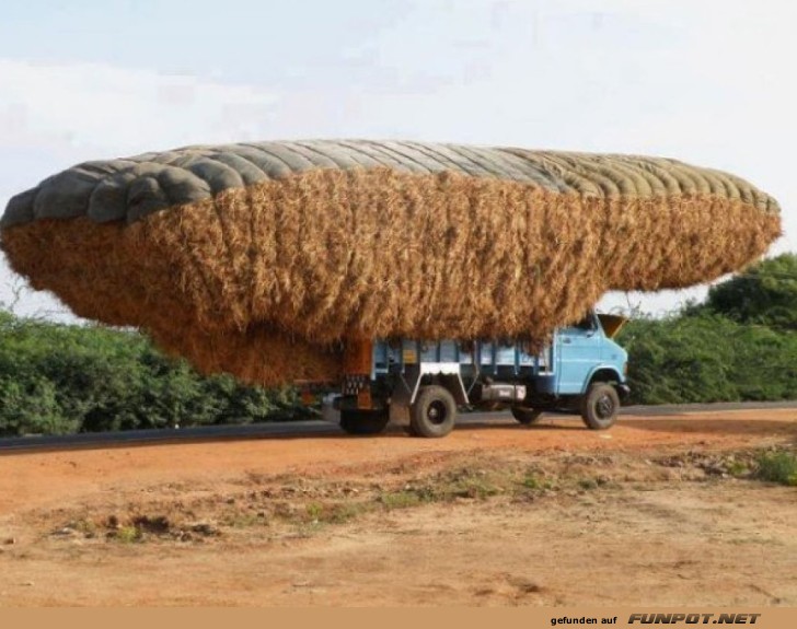 Überladener Transportwagen mit Heuballen Überladener Transportwagen mit Heuballen