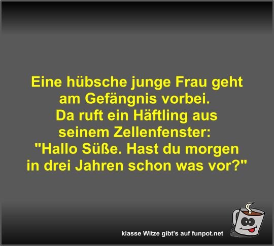 Eine hübsche junge Frau geht am Gefängnis vorbei