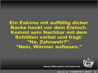 Ein Eskimo mit auff�llig dicker Backe hockt vor dem Eisloch