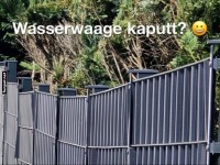 Schiefer Zaun mit humorvollem Text