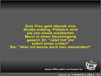 Eine Frau geht abends eine Straße entlang