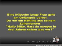 Eine hbsche junge Frau geht am Gefngnis vorbei