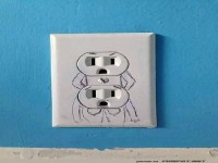 Kreative Steckdosenkunst an blauer Wand