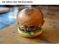 Lustiger Hamburger mit einem Kopf als Brötchen