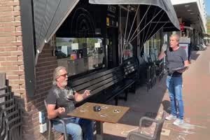 Coronazeiten.Kellner und Kunde halten Abstand in Holland